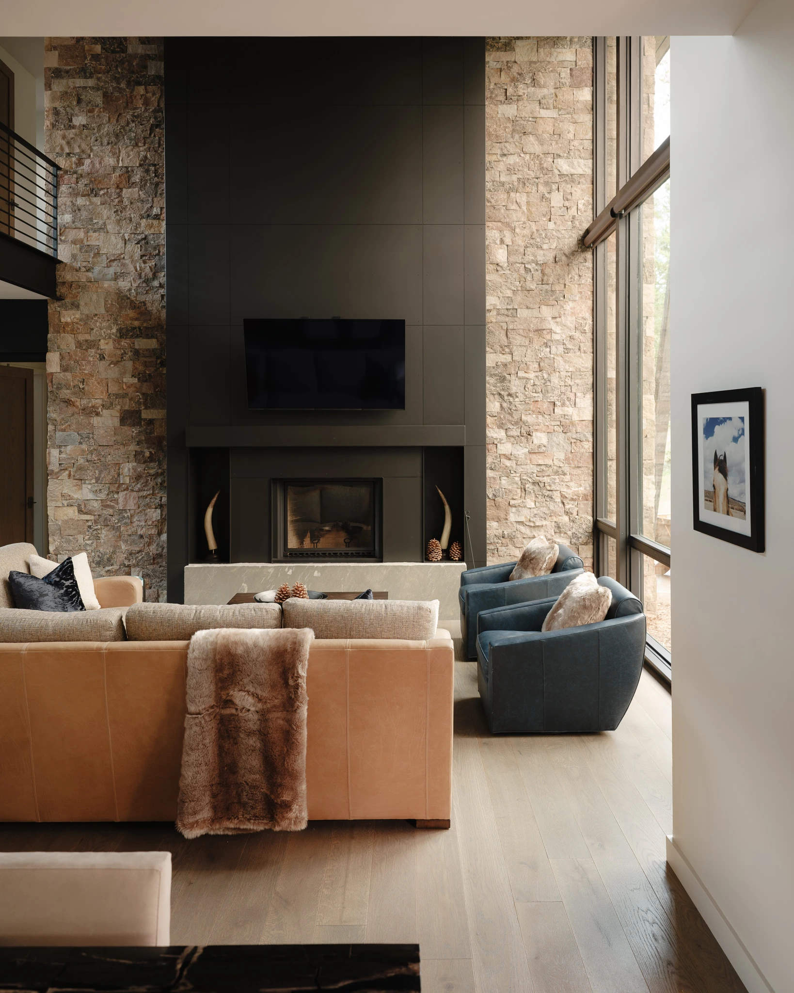 Great room fireplace with loft catwalk visible above — architectural photography Big Sky Montana, Speedwell Cabin